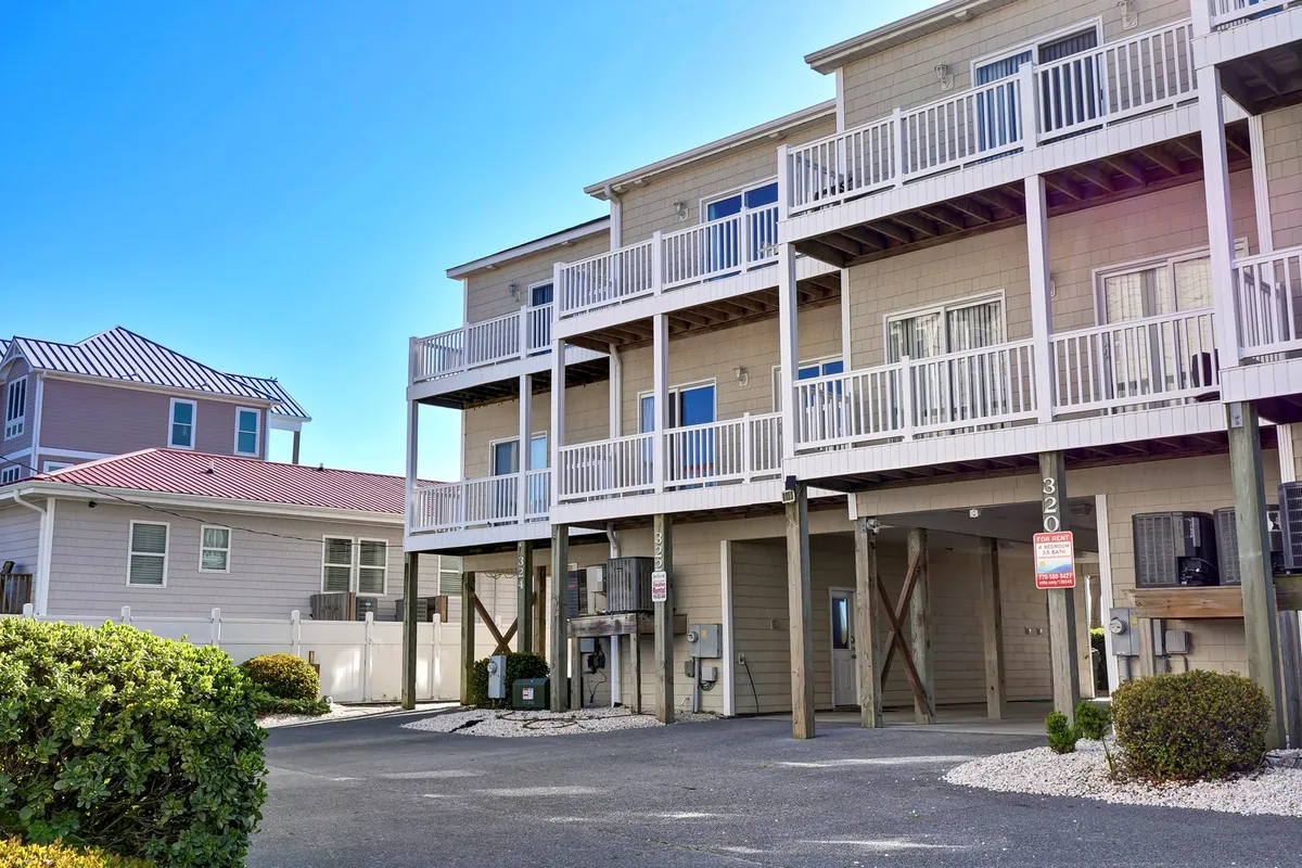 This image showcases a multi-story building with inviting balconies and manicured landscaping. Family members are seen enjoying the balcony, relaxing together, and sharing meals outdoors as the sun sets, emphasizing both the communal and private spaces available.
